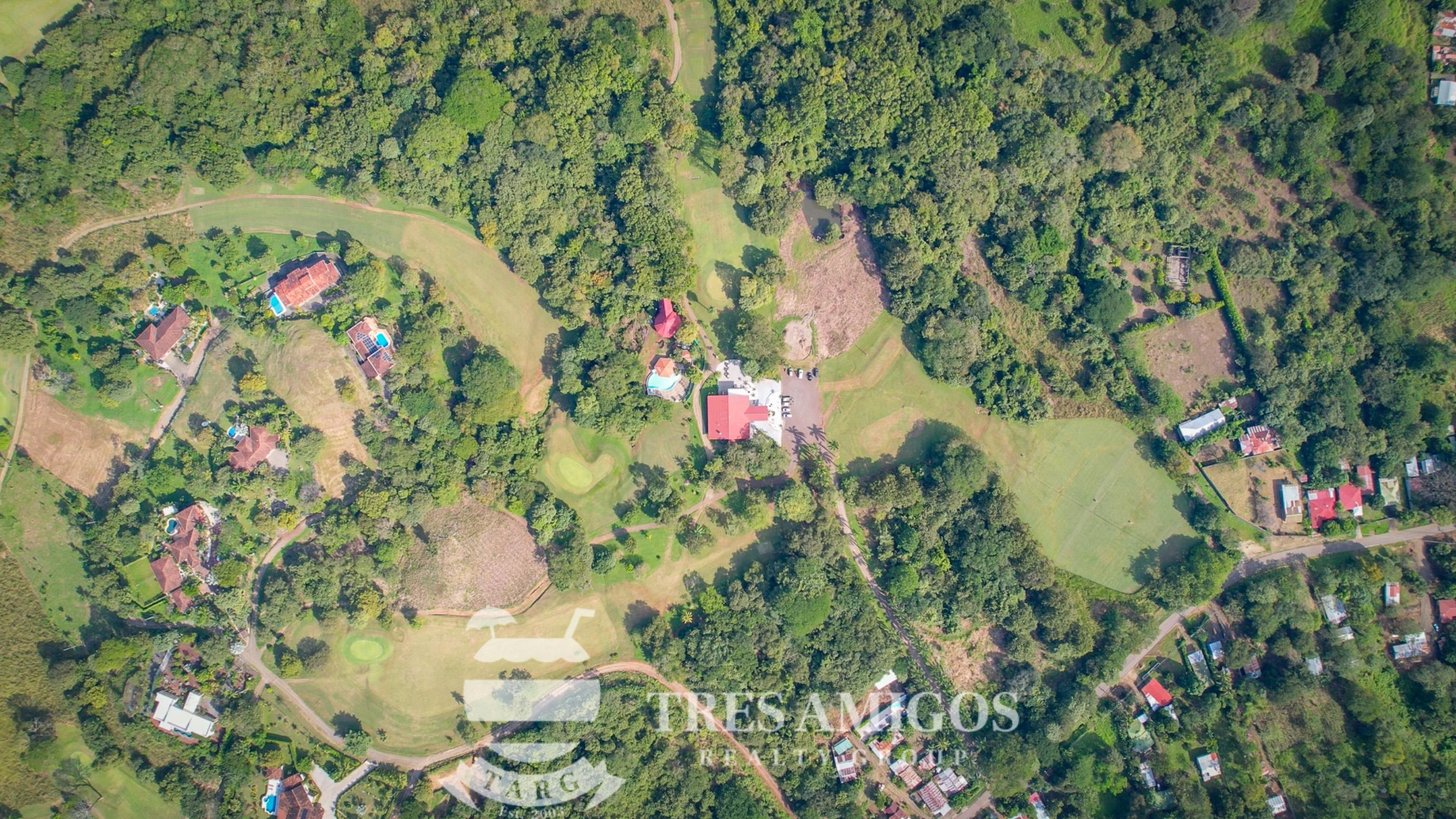 Aerial view of Sardinal town with houses surrounded by lush greenery.