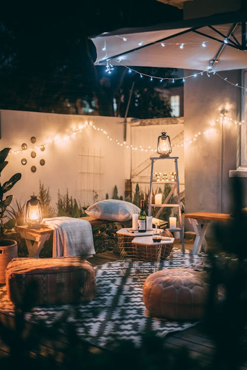 An image of a garden with carpets and fairy lights